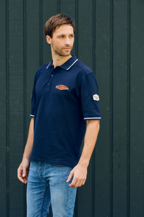 .
Mann trägt ein blaues Poloshirt aus der Böckmann Kollektion mit Logo auf der linken Brust.