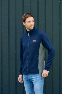 Mann trägt blaue Sweatjacke mit kleinem Logo auf der linken Brust aus der Böckmann Kollektion.